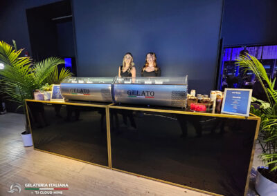 Two gelato tabletop units side by side with hospitality staff standing behind