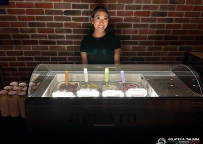 Hospitality Staff member standing behind gelato tabletop at night event